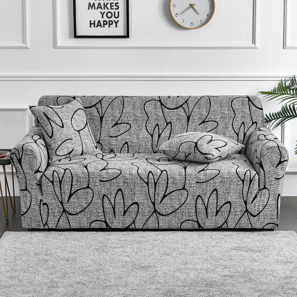 A gray elastic sofa cover protector featuring a black floral print on a sofa.