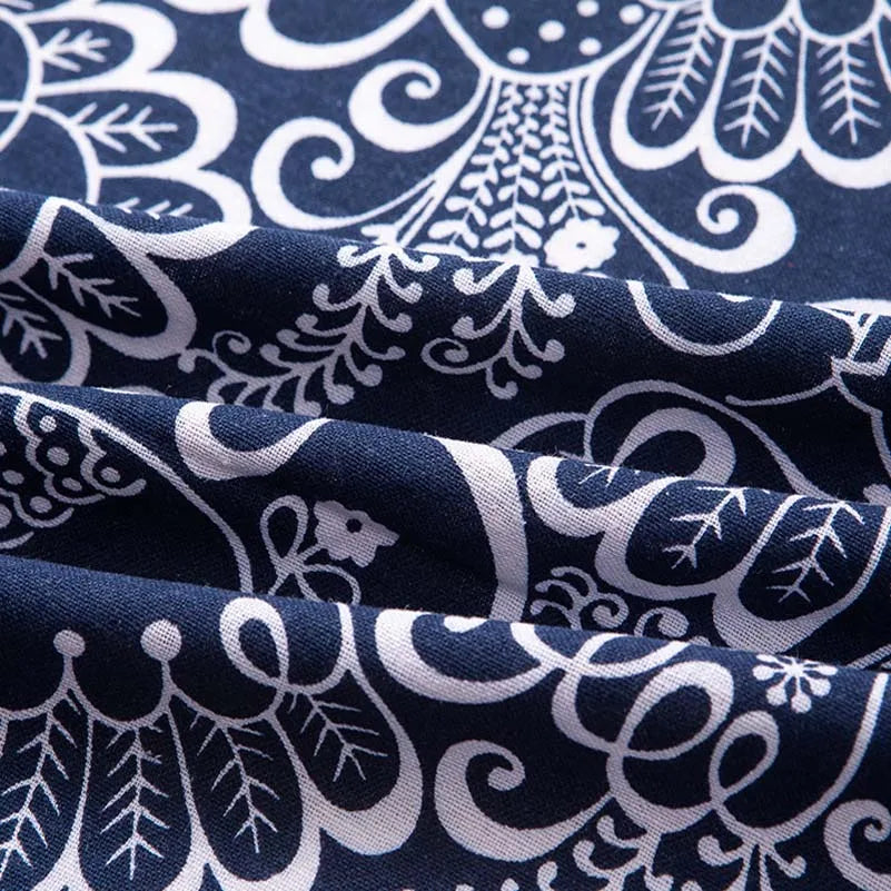 Close-up of dark blue and white bohemian printed linen fabric showing intricate floral and leaf patterns.