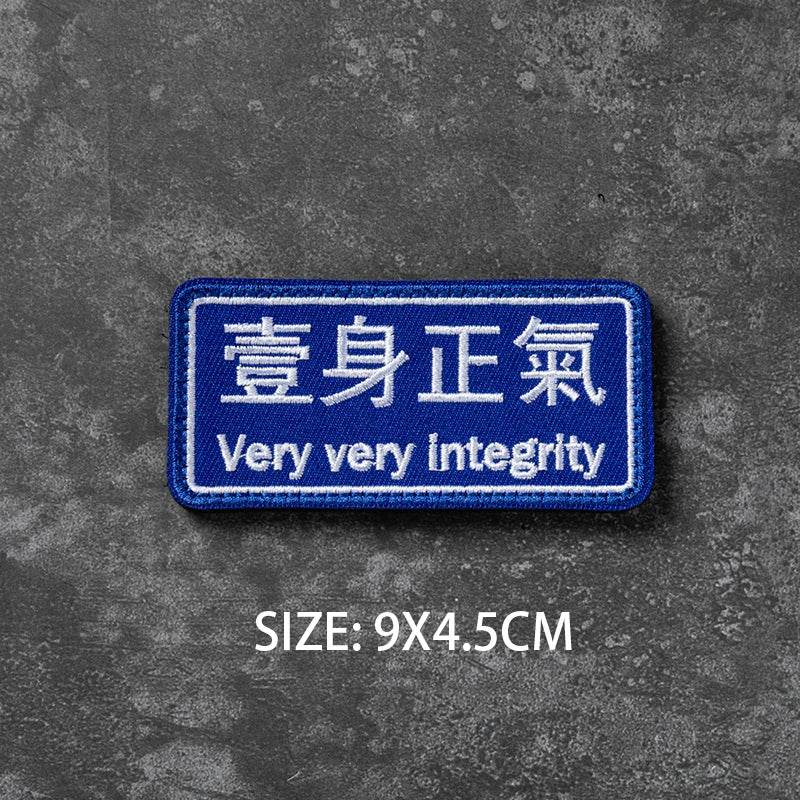 Blue embroidered badge with Chinese text meaning very integrity on a gray background