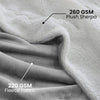 Close-up of a white plush sherpa fleece fabric layered over a gray fleece fabric.