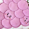 Close-up of a pink floral coral fleece hanging hand towel with embroidered face designs.