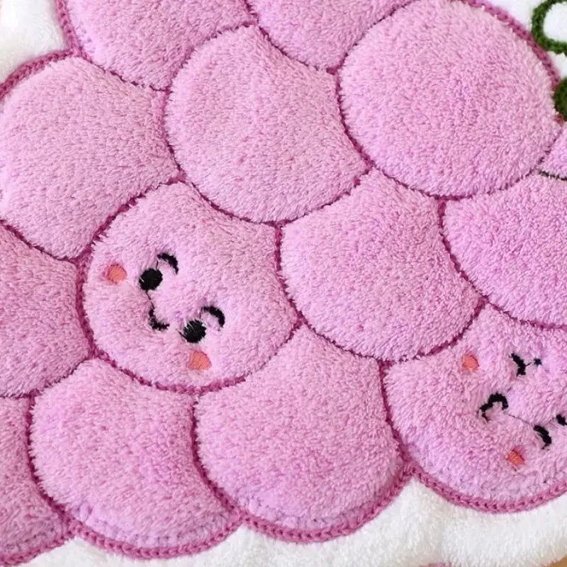 Close-up of a pink floral coral fleece hanging hand towel with embroidered face designs.