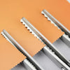 A pair of professional dressmaking pinking shears with silver blades resting on an orange fabric background.