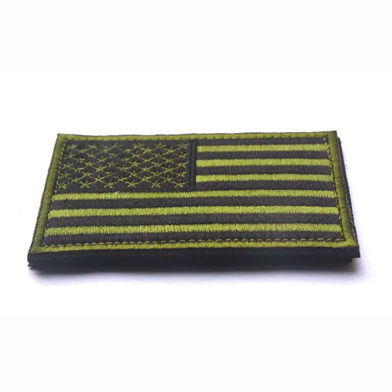 A rectangular patch featuring the design of the American flag with horizontal stripes and a canton, backed with hook and loop