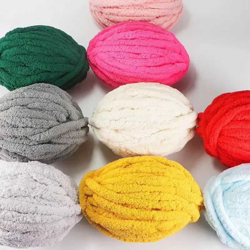 A collection of hand-knitted yarn balls in various shades including pink, green, gray, white, and red.
