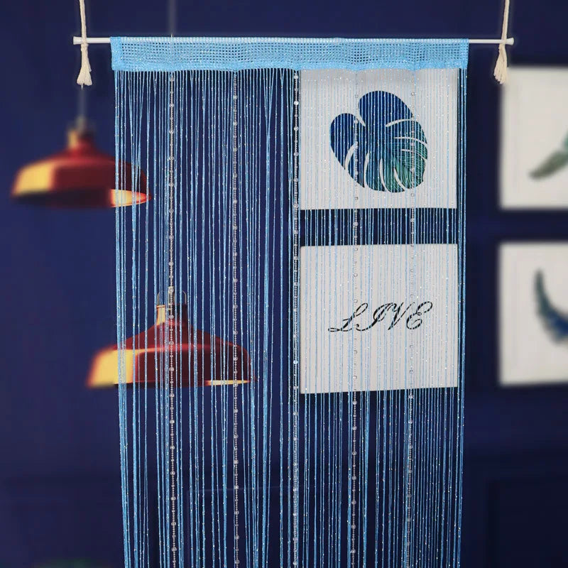 Blue beaded string curtains hanging vertically with a blue fabric panel featuring a teal leaf design and the word LIVE