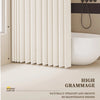 A close-up of a beige shower curtain with vertical pleats shown next to a white bathtub and a shower rod.