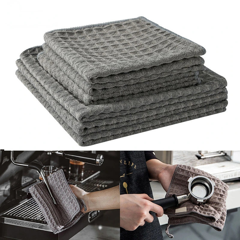 Stack of gray lint-free microfiber cleaning towels used for coffee machines and barista tasks