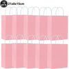 Ten pink paper gift bags with white handles stacked in a row