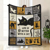 A black and yellow flannel throw blanket featuring various cat-themed quotes and illustrations.
