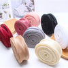 Rolls of silky organza ribbon in various colors including pink, red, gray, black, and cream for crafting