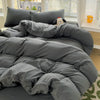 A gray solid cotton bed linen set with a duvet and pillows is displayed on a bed.