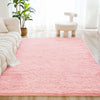A pink shaggy rug is placed on a light wooden floor in a bright room with a white stool and green plants.