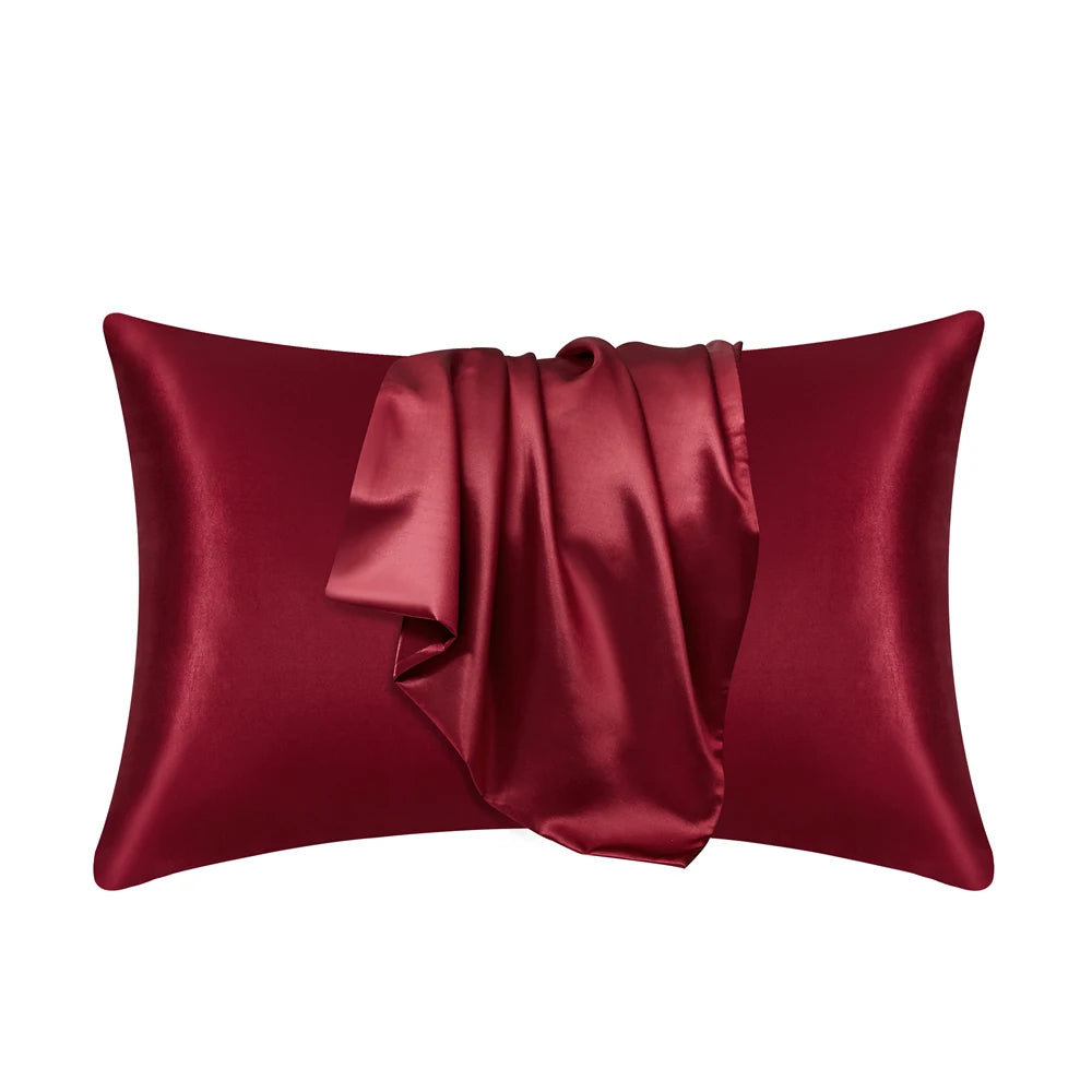 A deep burgundy satin silk pillow cover with a draped fold.