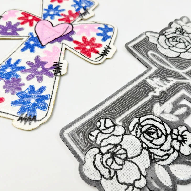A collection of colorful DIY iron-on embroidery patches featuring floral and heart designs on white fabric.