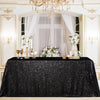 A black sequin glitter tablecloth is displayed on a table set within an ornate, gilded room decorated with white drapery and 