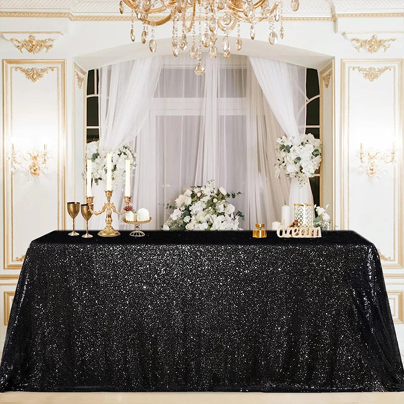 A black sequin glitter tablecloth is displayed on a table set within an ornate, gilded room decorated with white drapery and 