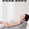 A person is lying down using a gray ergonomic memory foam wedge pillow for massage or support.