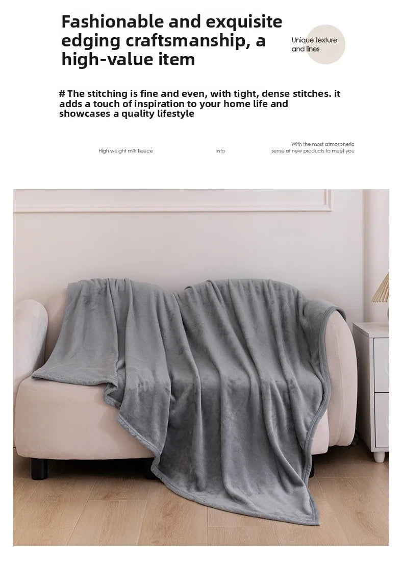 A soft gray flannel throw blanket draped over a light-colored sofa in a bright living room setting.