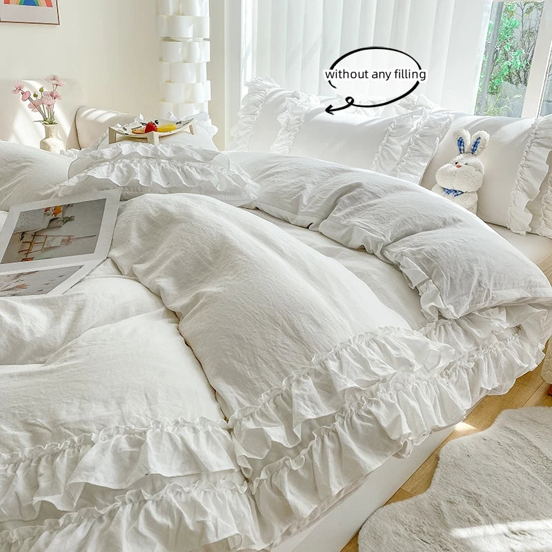 A white ruffled duvet cover set on a bed with natural light and decorative pillows.