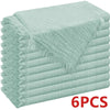 A stack of light mint green decorative cloth napkins rolled and folded.