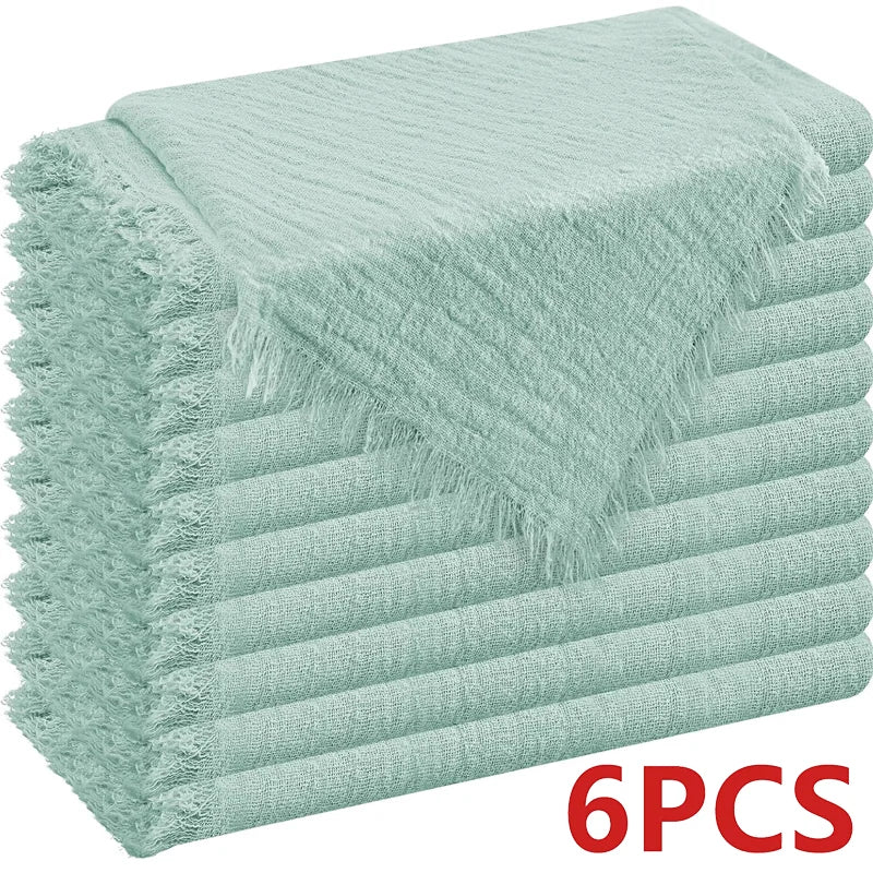 A stack of light mint green decorative cloth napkins rolled and folded.