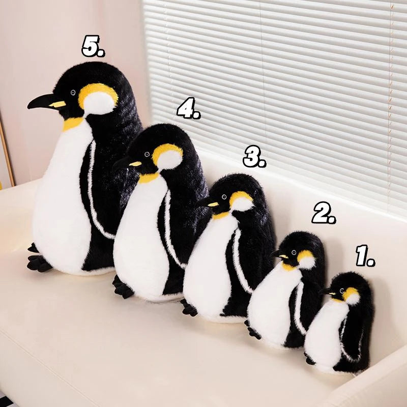 Five adorable black and white penguin plush toys lined up on a white surface.