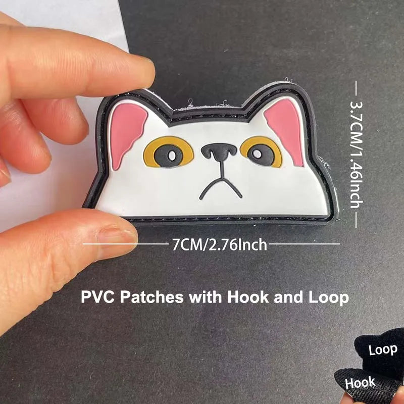 A white cat face patch with pink ears and yellow eyes is being held against a dark background.