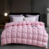 Pink quilted duvet with white pillows displayed on a dark bed against a gray wall.