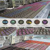 A long conveyor belt displays numerous iron-on embroidered sorority patches in various colors and designs.