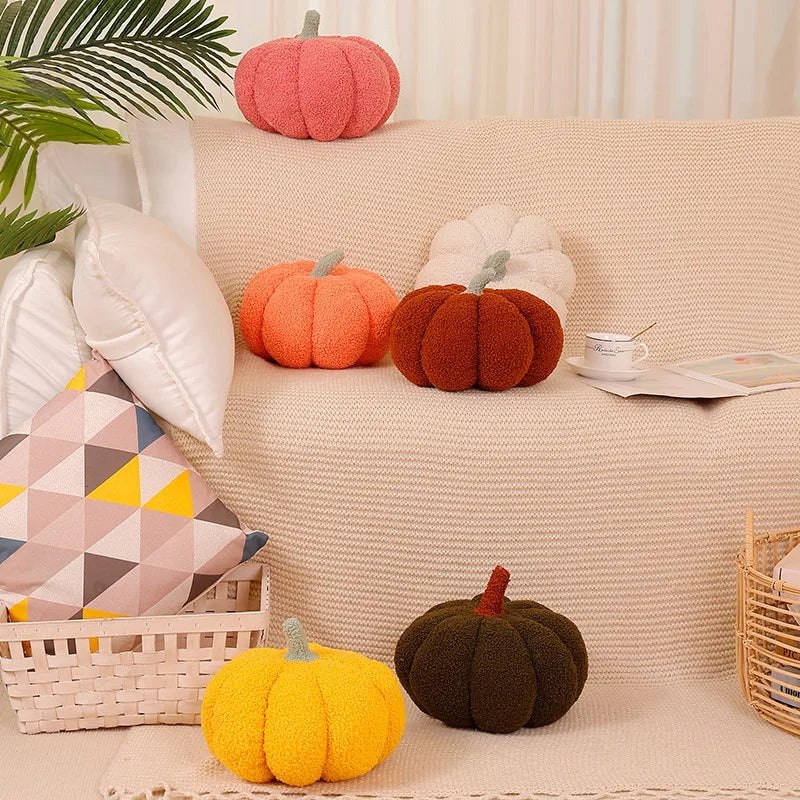 A collection of orange and green pumpkin shaped throw pillows displayed on a beige sofa cushion.