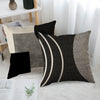 A close-up of a black and white abstract geometric throw pillow cover with curved lines and textured fabric.