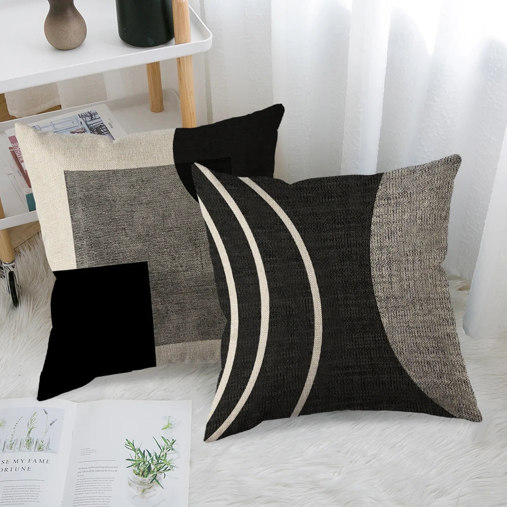 A close-up of a black and white abstract geometric throw pillow cover with curved lines and textured fabric.