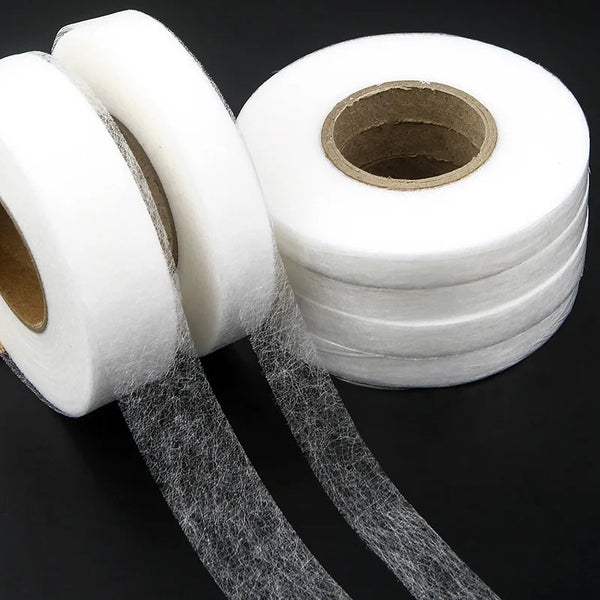 Rolls of white double-sided interlining fabric tape with strips unwound