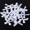 A pile of white satin ribbon bows for craft and decoration