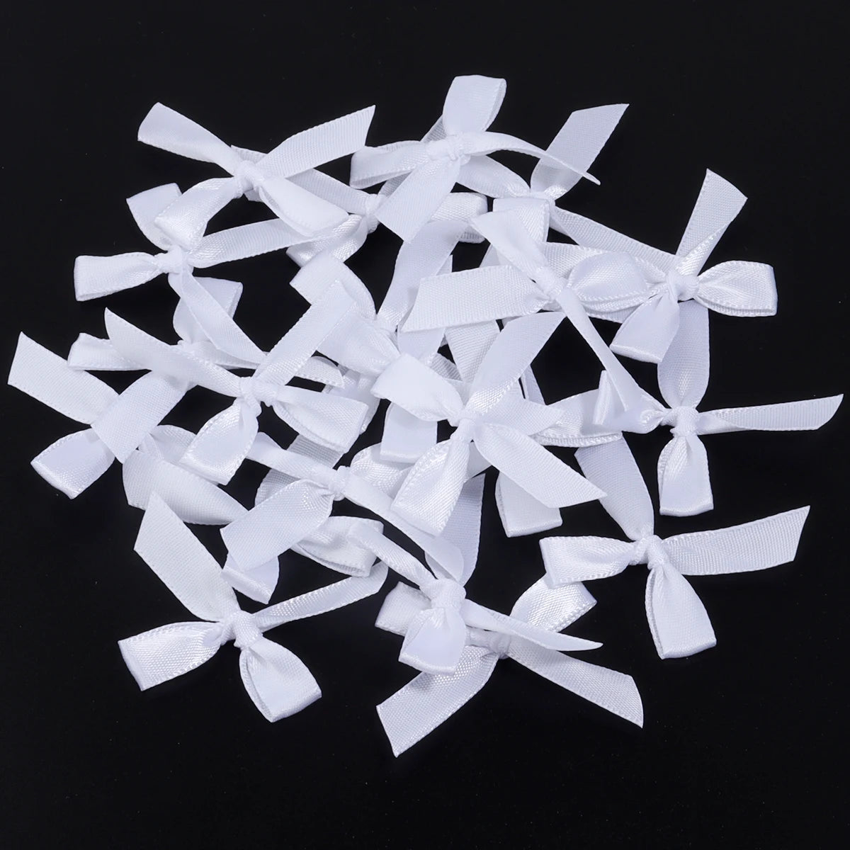 A pile of white satin ribbon bows for craft and decoration