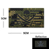 A dark olive green embroidery patch featuring a skull and crossbones design on a tactical background.