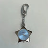 Silver star-shaped pocket watch keychain with a light blue face and silver chain.