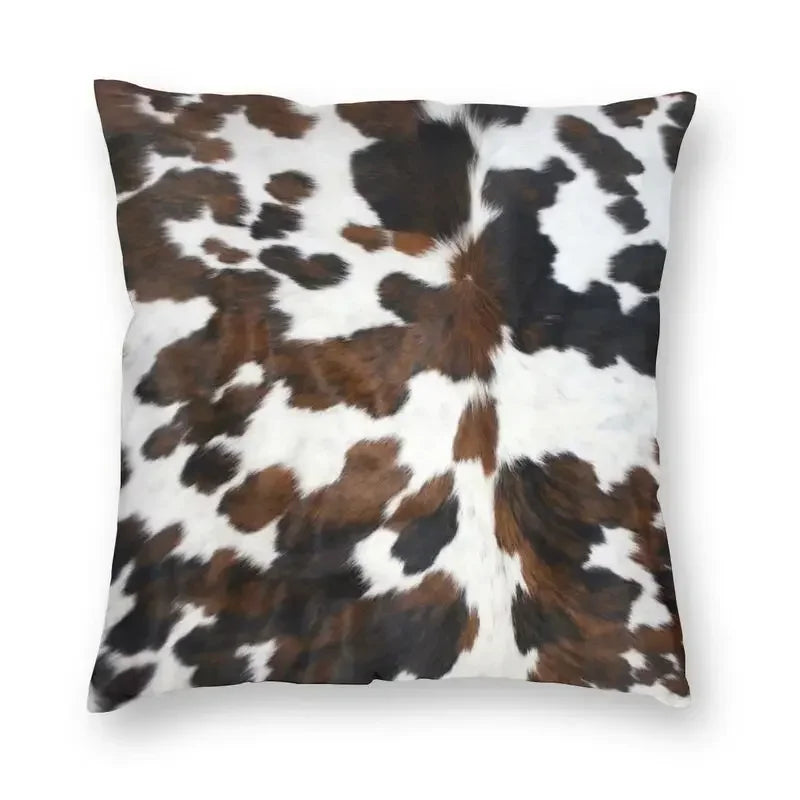 A square cushion cover featuring a brown and white cowhide print.