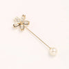 A delicate gold-toned brooch featuring a floral design and a pearl drop.