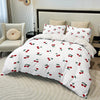 White duvet cover set with a red fruit print featuring cherries and green leaves on a bed.