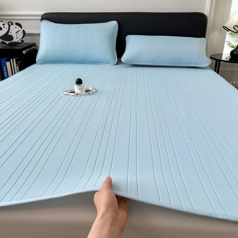 Light blue cooling ice silk bed pad with quilted texture placed on a bed.