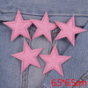 Five pink glitter star patches sewn onto a denim fabric.