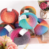 A collection of multi-colored wool yarn skeins in shades of pink, orange, blue, and purple arranged on a white surface.