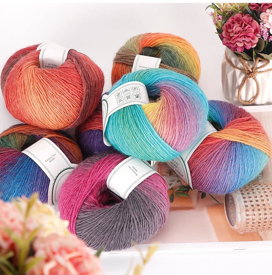 A collection of multi-colored wool yarn skeins in shades of pink, orange, blue, and purple arranged on a white surface.