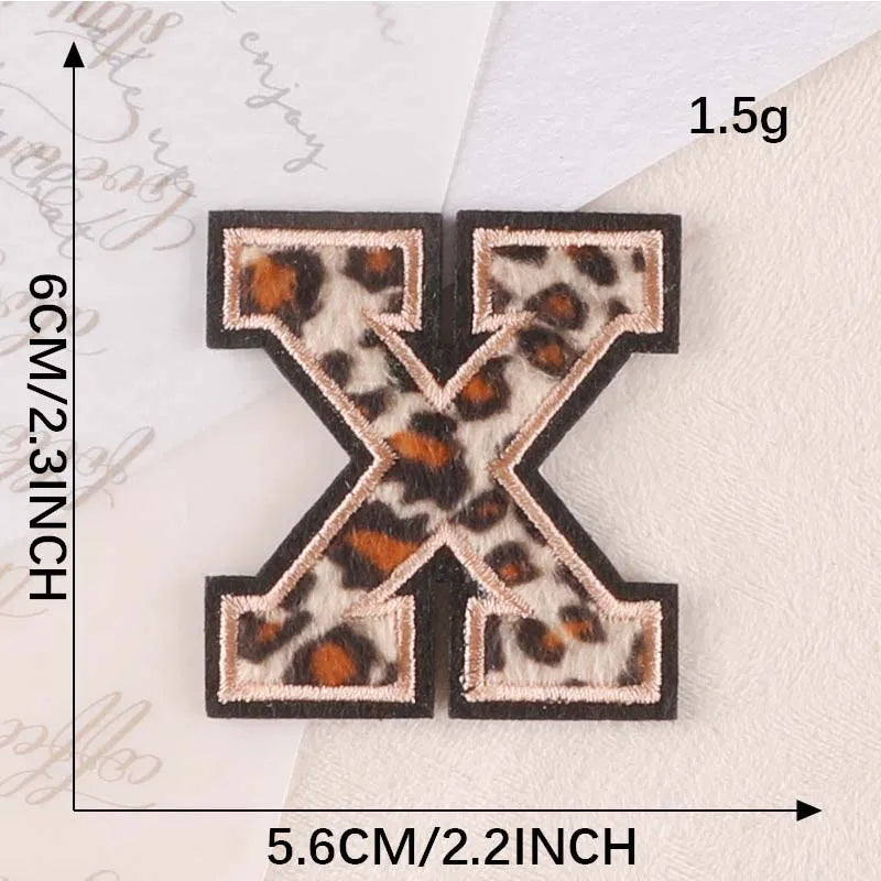 A black iron-on patch shaped like the letter X with a leopard print design.
