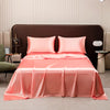 A pink satin flat bed sheet set is displayed on a bed with a brown headboard.