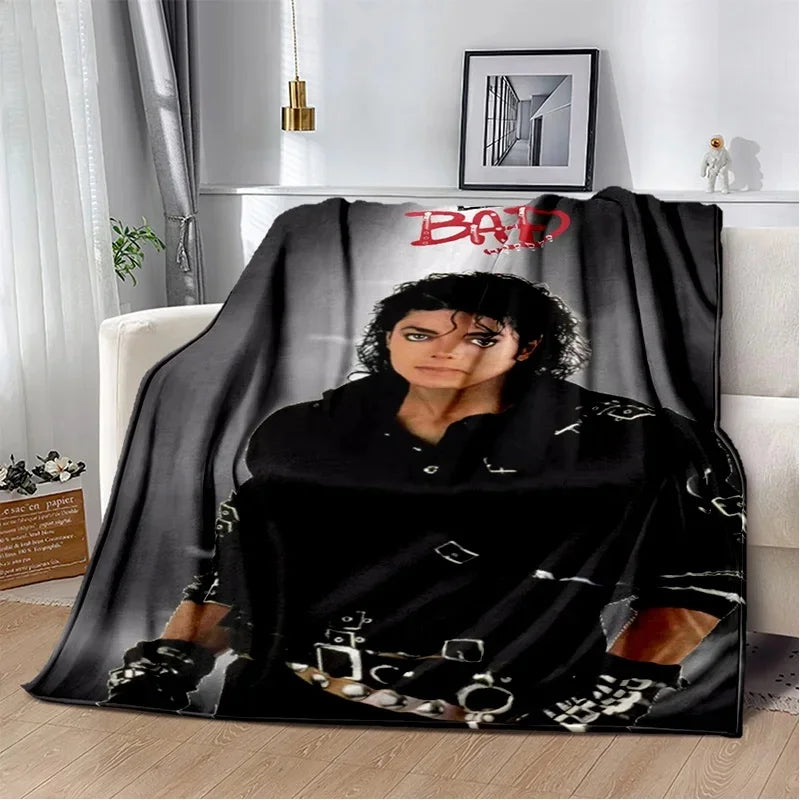 A black flannel throw blanket featuring a distressed graphic design and red text on a white background.