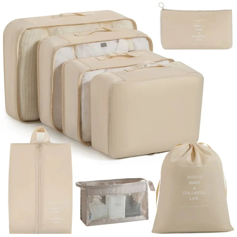 A set of beige travel storage organizers including a large box, smaller boxes, and a drawstring bag.