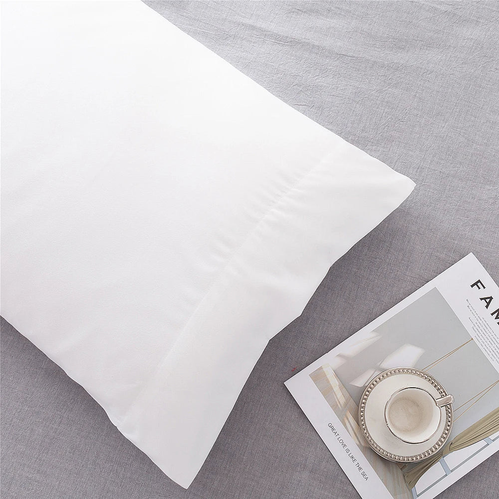White microfiber pillow covers displayed on a gray fabric background.